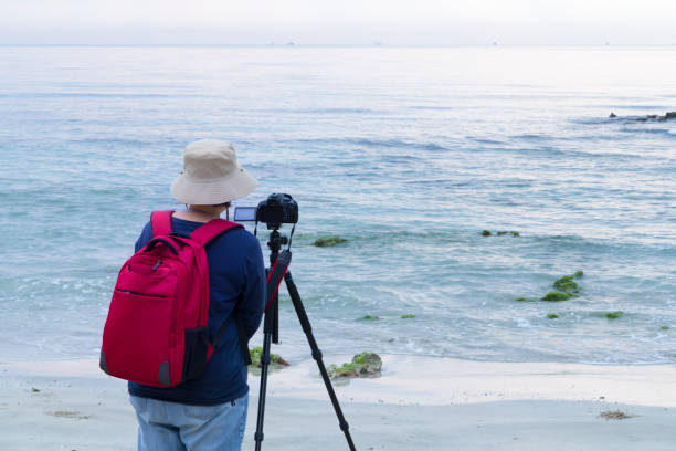 istock Photographer taking a photograph on the beach 912235766