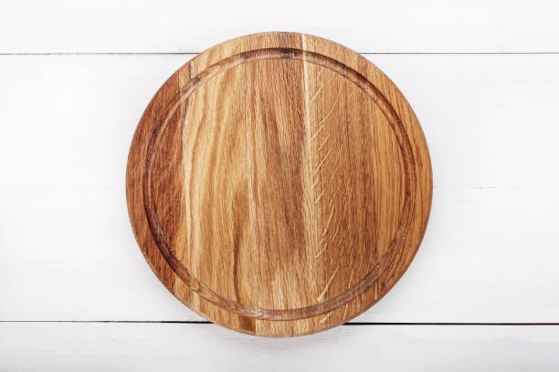 istock round wooden pizza board on a wooden background 912235768