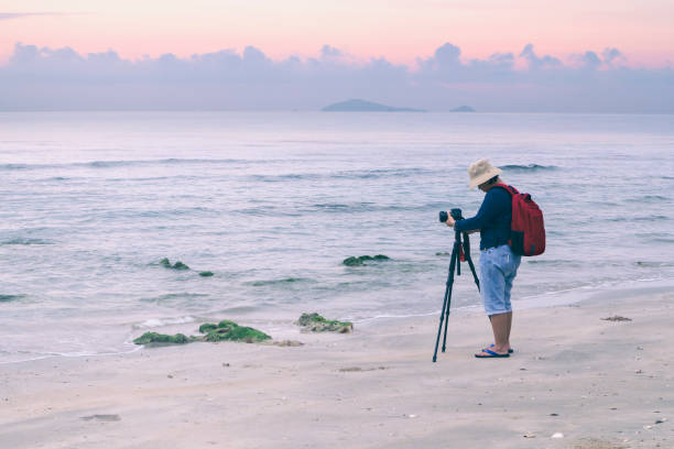 istock Photographer taking a photograph on the beach 912235798