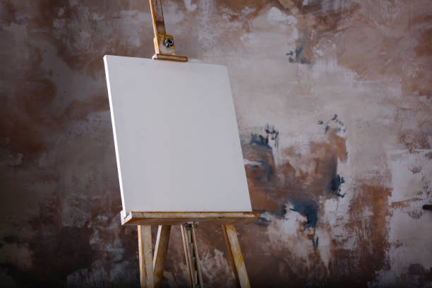 weiße leere künstlerische leinwand auf einer staffelei zum zeichnen von bildern von einem künstler auf einem grauen hintergrund - canvas artists canvas white frame stock-fotos und bilder