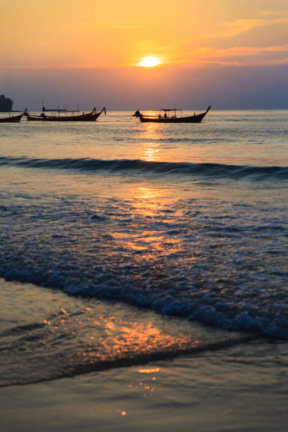istock Two longtail boat silhouette at sunset in Phuket, Thailand. Tropic travel destination. Meditative and simple seascape with copy space. 912242576