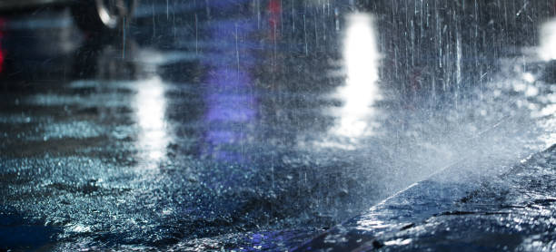 Hard rain fall at night with blurry cars. stock photo
