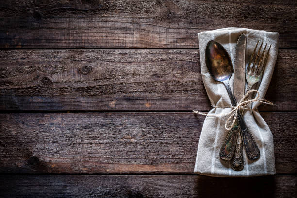 istock Vintage silverware on textile napkin shot from above on rustic wooden table 912244720