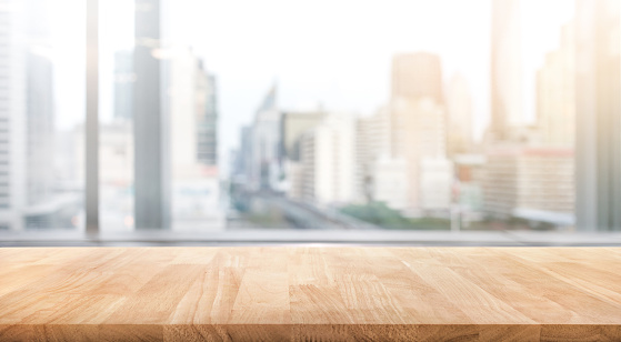 Empty wood table with blur room office and window city view background.For montage product display or design key visual layout.