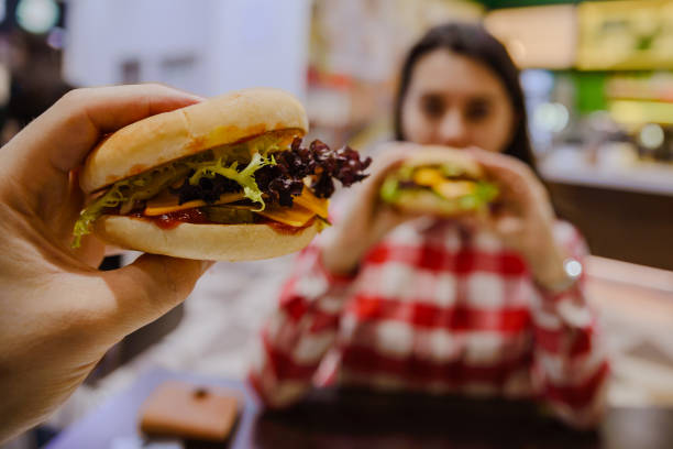 istock couple eat cheeseburgers in cafe 912248872
