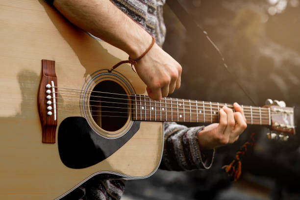 joven músico tocar la guitarra acústica de cerca - concierto fotografías e imágenes de stock