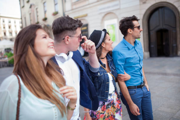 Group of four young people having fun in a city of Cracow (Kraków, Poland).