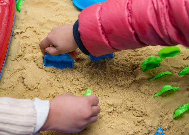 istock kids playing sand and plastic moulds 912259330
