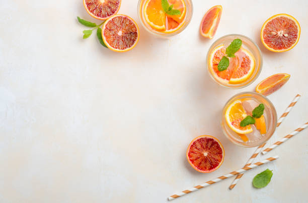 istock Cold refreshing drink with blood orange slices in a glass on a white concrete background. 912263192