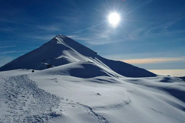 Snowy mountain scenery in Italian Alps, in a sunny day with low cloud in background