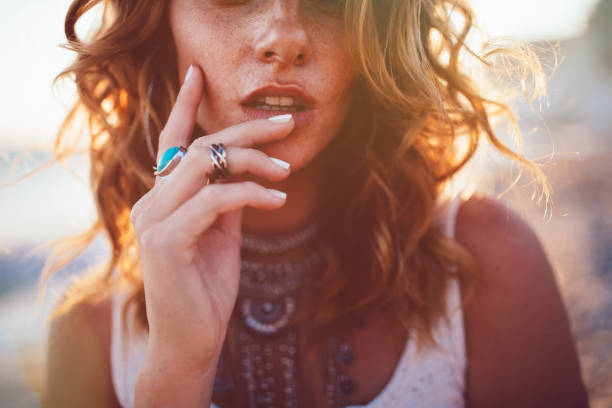 Young woman wearing bohemian style silver jewelry Close-up of bohemian woman with freckles wearing boho style silver turquoise rings and necklaces wavy hair stock pictures, royalty-free photos & images