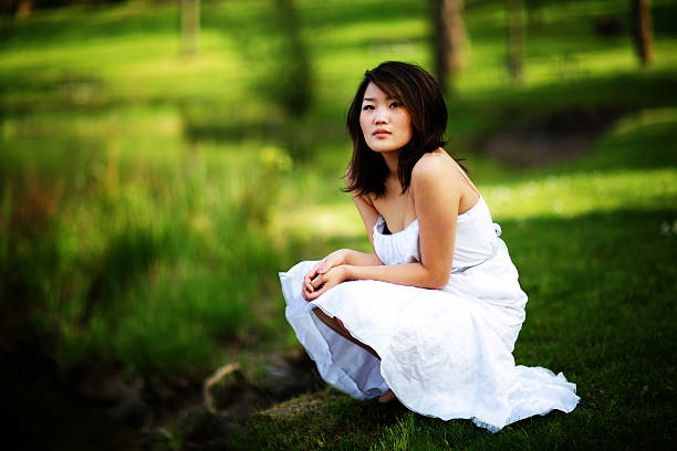 istock Asian Female Knelt Down by Water Pondering 91227276