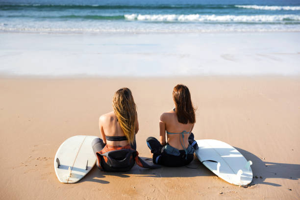 istock Surfer girls at the beach 912274424