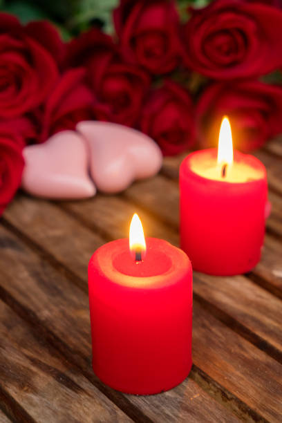 istock Two burning candles with fresh roses 912277374