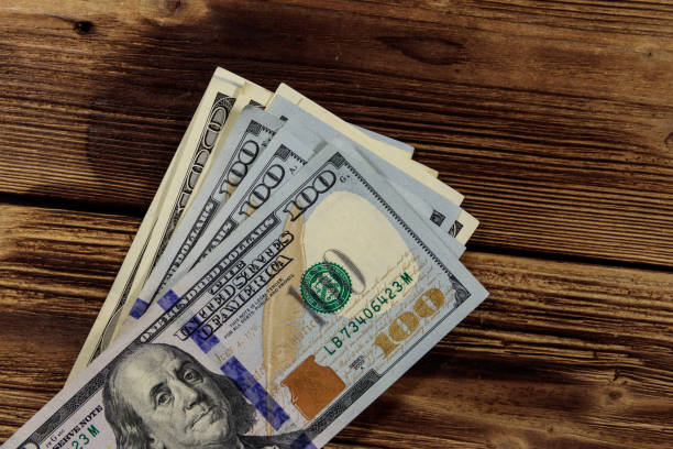 istock Stack of one hundred dollars bills on wooden desk 912277966