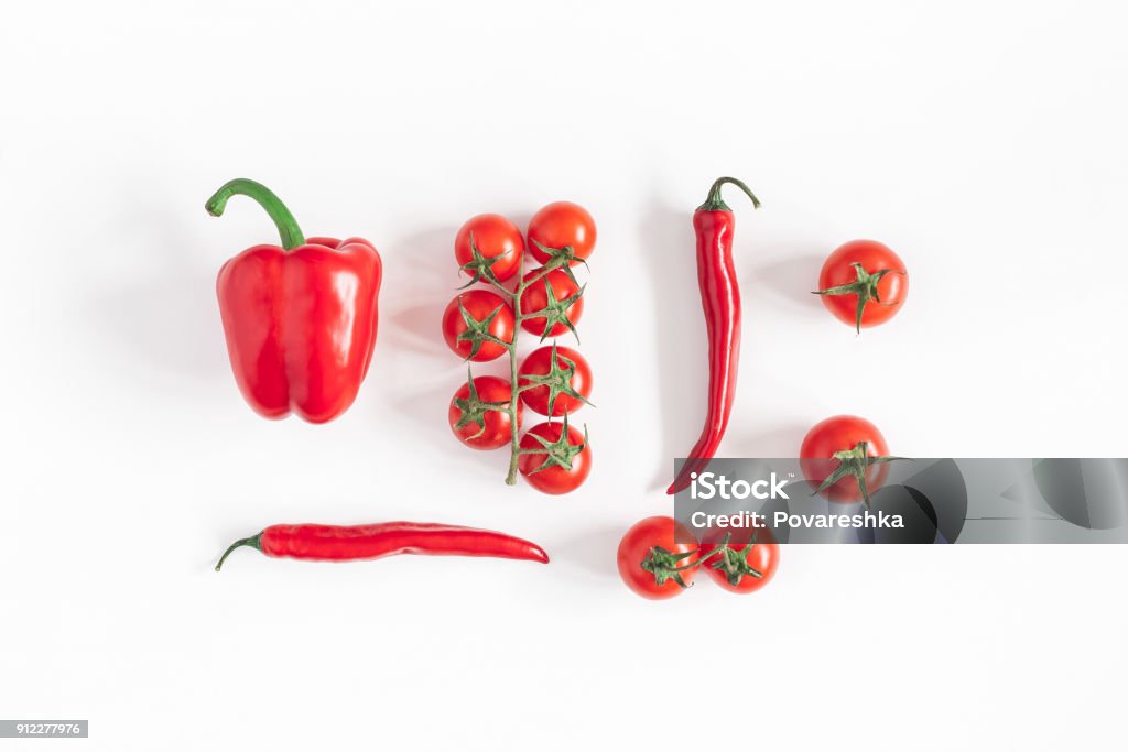 Red vegetables on white background. Flat lay, top view Vegetables on white background. Pattern made of fresh red vegetables. Tomatoes, peppers. Flat lay, top view Cherry Tomato Stock Photo