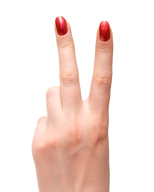 Woman shows victory sign with polished nails stock photo