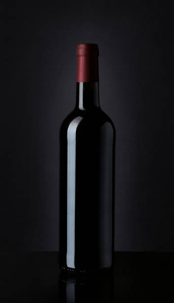 bottiglia di vino rosso su sfondo nero - wine bottle bottle burgundy wine foto e immagini stock