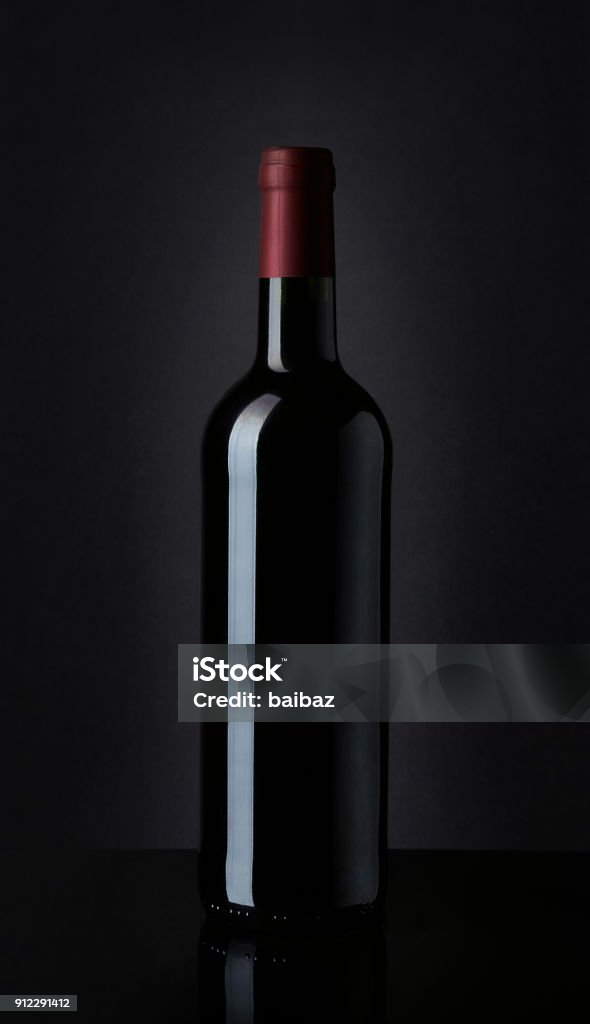 Bottle of red wine on black background Dark bottle of red wine on black background Template Stock Photo