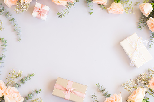 gift or present boxes and flowers frame on blue background from above, copy space