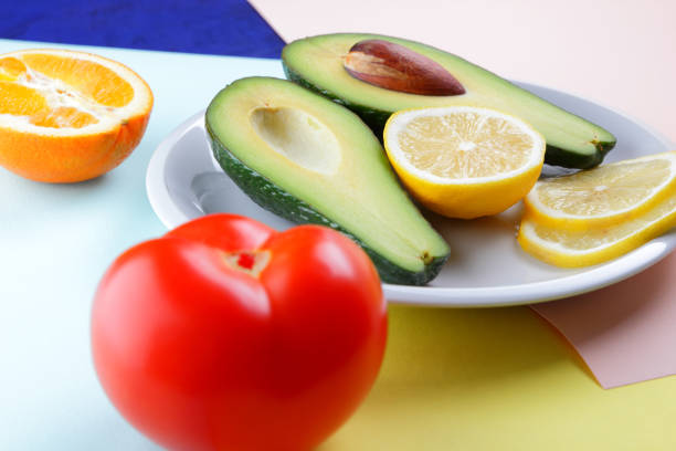 Avocado, lemon and half orange on a colorful background, tropical fruit pop art, vegetarian breakfast, Asian cuisine, avocado pop art, citrus, orange with avocado, art