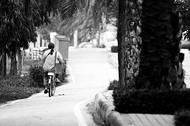 Vinh Long, Vietnam June 07, 2025 - A father and his young daughter on a motorbike wait for mother to finish work at Hoa Phu Industrial Zone in the afternoon.