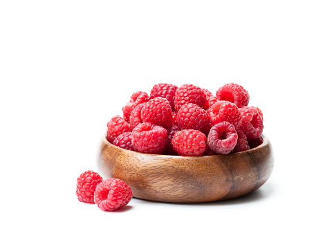 Fresh  selected raspberries on wooden bowl isolated on white