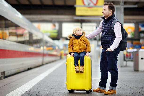 istock Smiling little boy and his father waiting express train on railway station platform 912300212