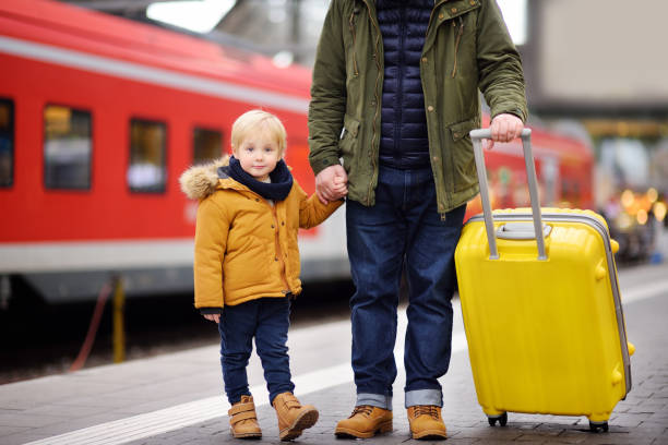 istock Smiling little boy and his father waiting express train on railway station platform 912300214