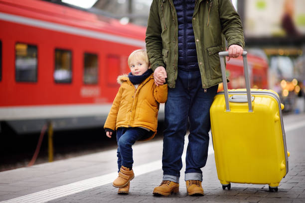 istock Smiling little boy and his father waiting express train on railway station platform 912300238