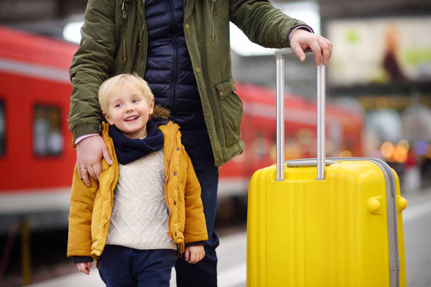 istock Smiling little boy and his father waiting express train on railway station platform 912300256