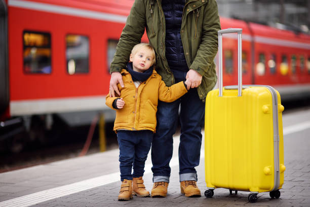 istock Little boy and his father waiting express train on railway station platform 912300268