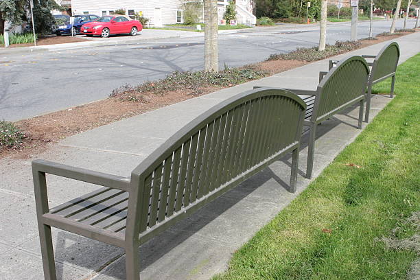 istock Row of bench chairs facing a road 91230433