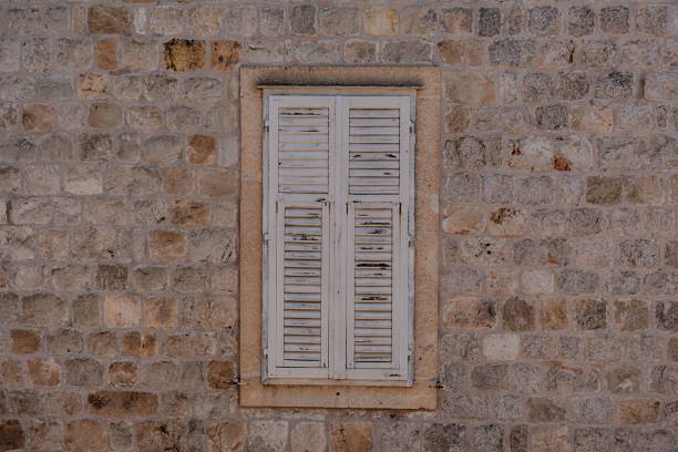Closed windows with shutters in a stone house