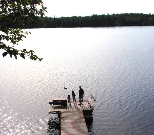 istock Mother and two young daughters on the dock. 912318646