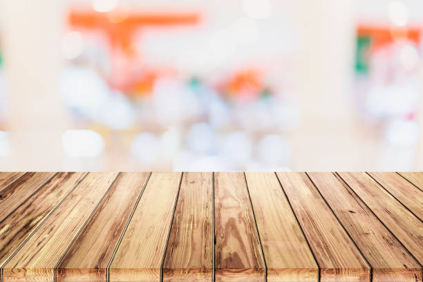 istock Empty wooden table with blur shopping mall background. 912319070