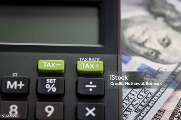 Tax Cuts Or Reduce Concept Closed Up Shot Of Tax Minus Plus Buttons With Text Tax Rate On Calculator With Background Of Blurred Us Dollar Banknotes United States Government Tax Overhaul Policy Stock Photo - Download Image Now