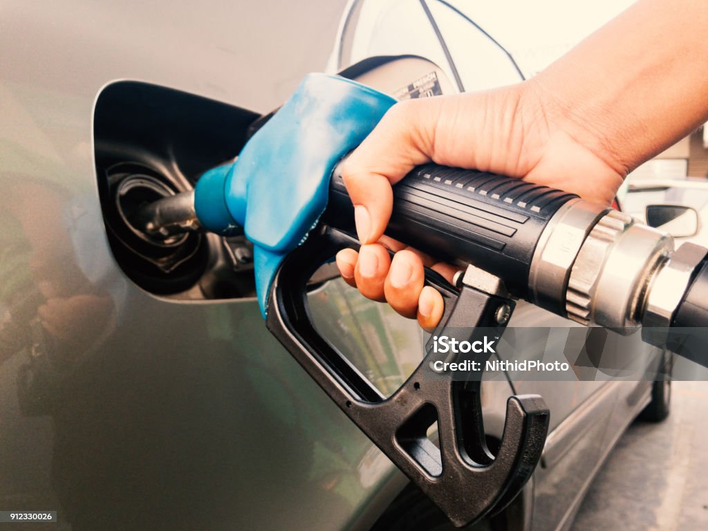 Ugello benzina con mano - Foto stock royalty-free di Fare il pieno di benzina