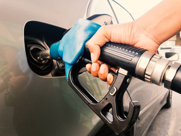 Hand holding gasoline nozzle Hand holding gasoline nozzle for car refueling at gas station refueling stock pictures, royalty-free photos & images