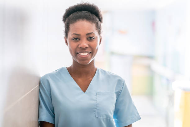 African american doctor wearing scrubs looking at camera smiling Portrait of beautiful african american doctor wearing scrubs looking at camera smiling occupational therapy photos stock pictures, royalty-free photos & images