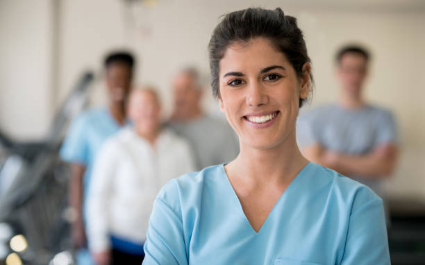 vackra sjukgymnast på kliniken tittar på kameran leende - smiling nurse bildbanksfoton och bilder