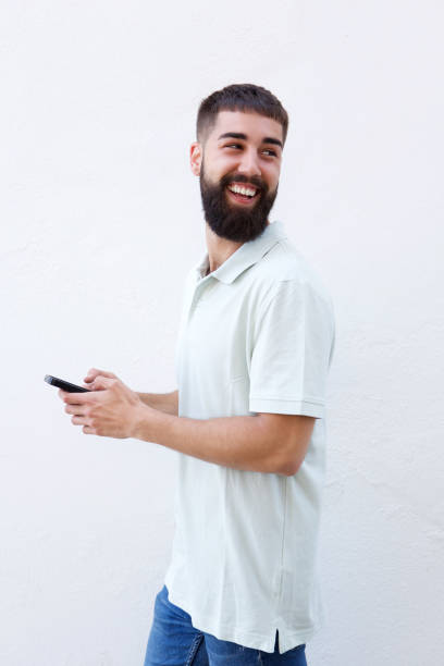 istock Laughing man with beard holding smart phone 912334278