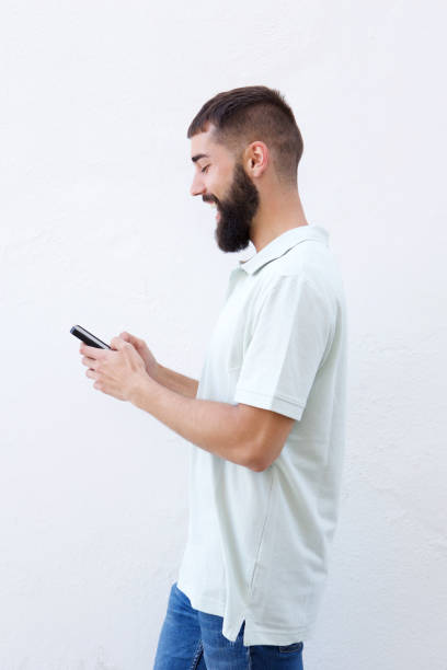 istock Laughing man with beard holding mobile phone 912334280