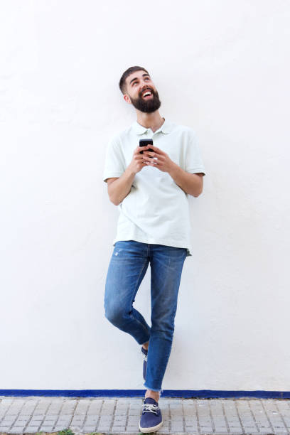 istock Full length handsome man standing and holding mobile phone 912334308
