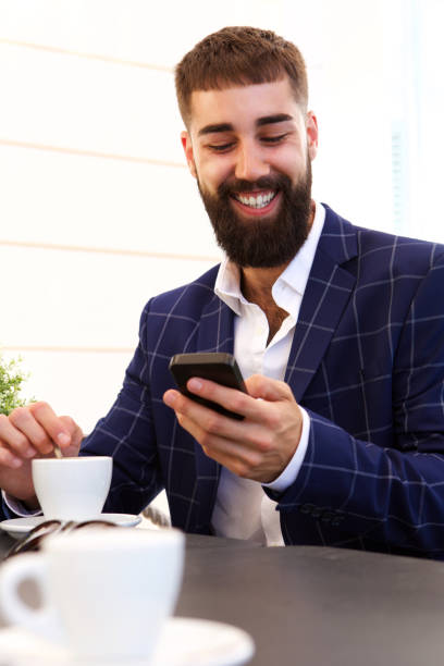 istock Happy businessman holding smart phone with coffee 912334340