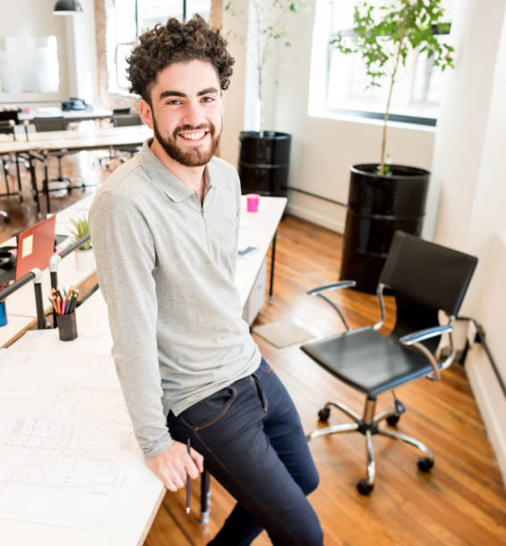 istock Portrait of a happy man working at a creative office 912334894