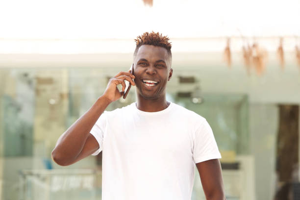 istock Laughing young afro american man standing outdoors and making a phone call 912334918