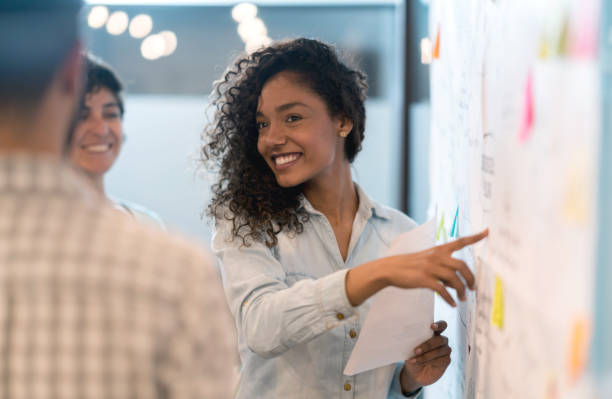 istock Woman sketching a business plan with her team at a creative office 912337870
