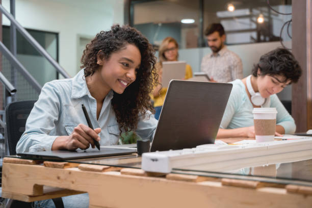 istock Happy graphic designer working on a laptop at a creative office 912338182