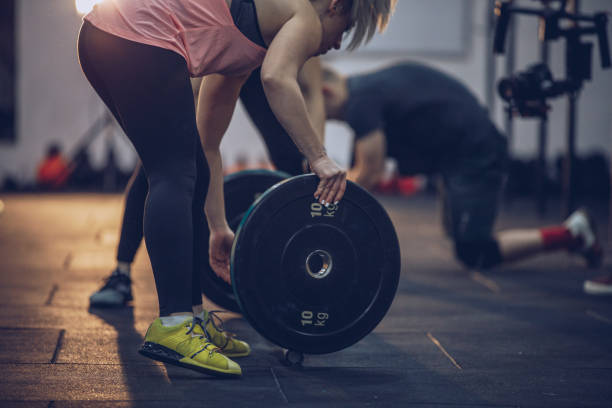 istock Woman lifting weights in the gym 912341264